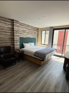 a bedroom with a bed and a chair at Skylux Hotel - Long Island City in Queens +2 photos
