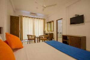 a bedroom with a bed and a table with chairs at Okwin Resort Nawalapitiya in Kandy