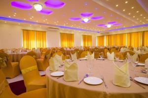 a large banquet hall with tables and yellow chairs at Okwin Resort Nawalapitiya in Kandy +65 photos