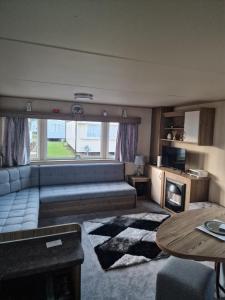 a living room with a couch and a table at Haggerston Castle Towerlawn 50 in Cheswick