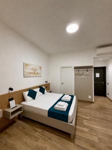 ein Schlafzimmer mit einem großen Bett und blauen Kissen in der Unterkunft CHD Rooms in Ancona