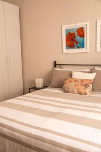 a bedroom with a bed with a striped mattress at Savian Apartment in Savigliano