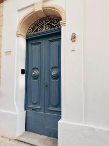 a blue door in a white building at Maltese House Gzira Central in Il-Gżira