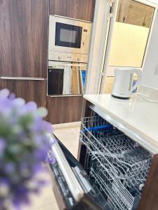a dishwasher in a kitchen with a microwave at Maltese House Gzira Central in Il-Gżira +2 photos