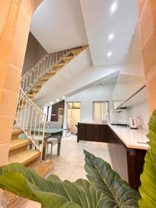 a kitchen and living room with a spiral staircase at Maltese House Gzira Central in Il-Gżira