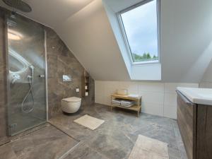 a bathroom with a shower and a toilet and a window at Chata na Lániku in Švošov +27 photos