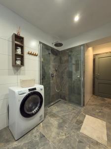 a washing machine in a bathroom with a shower at Chata na Lániku in Švošov