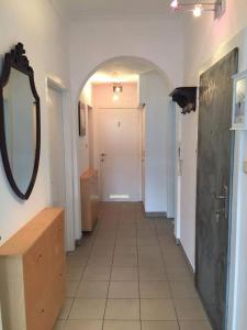 - un couloir dans la salle de bains pourvue d'un miroir et d'un lavabo dans l'établissement Résidence Stiénon, à Bruxelles