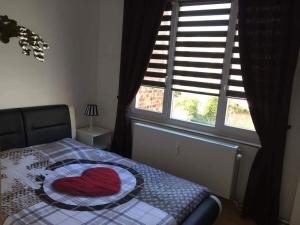 Un dormitorio con una cama con un corazón. en Résidence Stiénon, en Bruselas