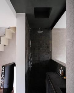 a bathroom with a shower with a black counter at Wabi Guesthouse in Ghent +13 photos