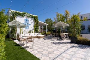 a patio with chairs and tables and umbrellas at Aliza Hotel in Los Angeles