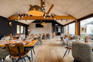 a restaurant with wooden tables and chairs and windows at Hotel & Restaurant Maison Pal'Ange in Durbuy