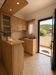 a kitchen with a sink and a large window at STUDIOS ATHENA in Megalochori