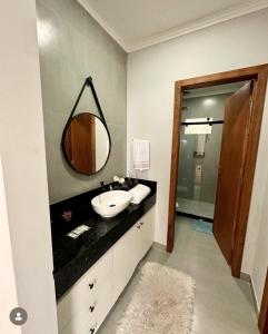 a bathroom with a sink and a mirror at Casa 3 Quartos Recanto Buritis in Santa Teresa +36 photos