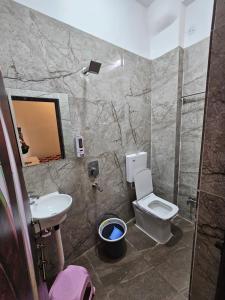 a bathroom with a sink and a toilet and a mirror at Siyara Hotel in Khamaria +21 photos