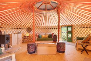 a yurt with a couch and chairs in a room at Jurte Falken Nest in Eisenbach