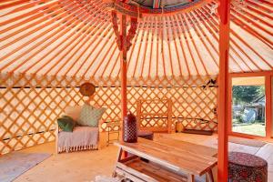 a large yurt with a wooden bench and a chair at Jurte Falken Nest in Eisenbach