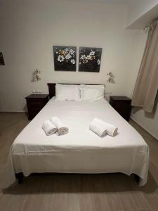 a white bed with two white towels on it at Psichro Apartments Hera in Magoulás