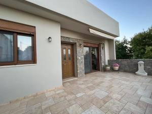 a house with a patio in front of it at Psichro Apartments Hera in Magoulás