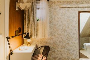 a bathroom with a desk and a lamp and a window at Graça Guest House in Lisbon