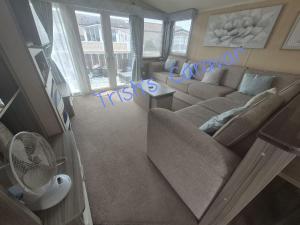 a living room with a couch and a table at Trish's Caravan Coop 144 in Kinmel Bay