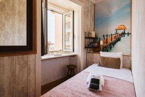 a room with a bed with a window and a phone on it at Graça Guest House in Lisbon