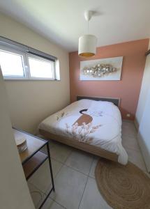 a small bedroom with a bed and a table at Chambre d'hôte Escale piscine in Ghislenghien +6 photos