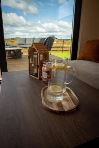 a table with a glass of water and a tray with a drink at Stodoła Nad Dadajem in Kojtryny