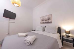 a bedroom with a large white bed with towels on it at Angie's House Volos in Volos +24 photos
