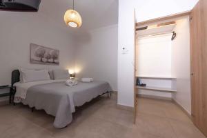 a white bedroom with a bed and a window at Angie's House Volos in Volos