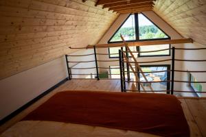 an attic room with a bed and a window at Stodoła Nad Dadajem in Kojtryny