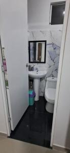 a bathroom with a sink and a toilet and a mirror at Casa La Torre in Lurín