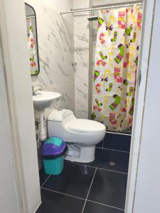 a bathroom with a toilet and a sink and a shower curtain at Casa La Torre in Lurín