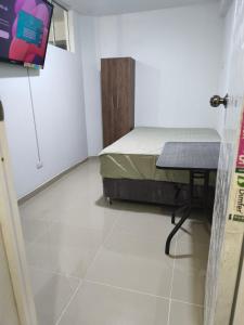 a room with a bed and a table in it at Casa La Torre in Lurín