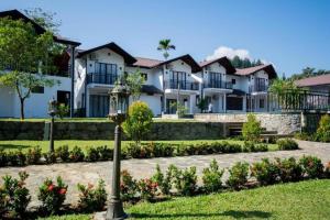a row of houses with flowers in a park at Okwin Resort Nawalapitiya in Kandy