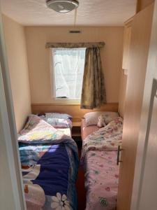 a small room with two beds and a window at Jay Valley Van in Flamborough +3 photos