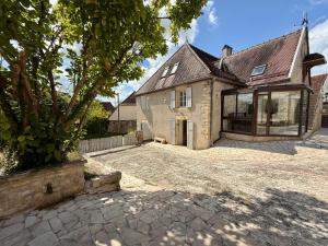 an old stone house with a large driveway at Le Petit Refuge - La Petite Longère in Rahon