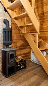 a wood stove sitting next to a wooden staircase at Guest House Zabljak in Žabljak