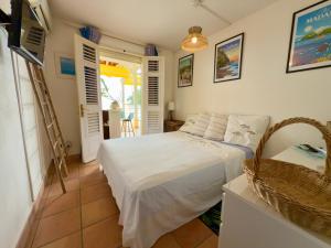 a bedroom with a white bed in a room at VILLA PASKEDRA in Case-Pilote +29 photos