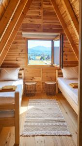 a bedroom with two beds and a large window at Guest House Zabljak in Žabljak