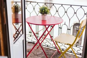 a red table and a chair on a balcony at Graça Guest House in Lisbon +24 photos