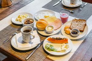 a table with plates of food and cups of coffee at Pousada Casa da Lagoa in Florianópolis