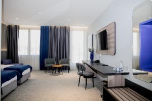 a hotel room with a bed and a desk at Hotel President in Čapljina