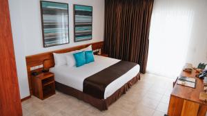 a hotel room with a bed and a desk at Hotel Cucuve in Puerto Ayora