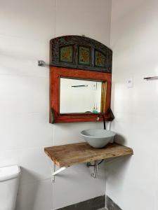 a bathroom with a sink and a mirror on the wall at Chalés do Chá in Lavras Novas