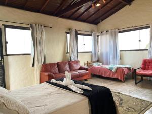 a living room with two beds and a couch at Chalés do Chá in Lavras Novas