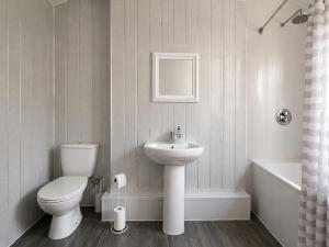 a white bathroom with a toilet and a sink at 52 - room 1 - city views in Swansea