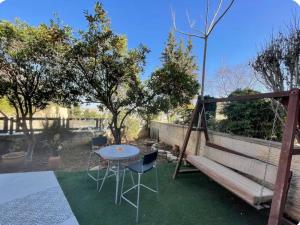 a patio with a table and chairs and a swing at בוטיק בהרי הקסטל in Mevasseret Zion