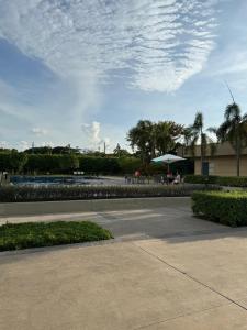 a patio with a table and an umbrella in a park at Maison Angela Suites in Biñan