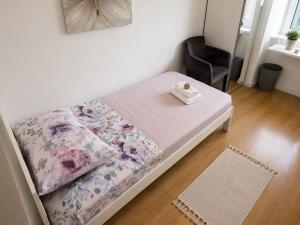 a small bed with a blanket and a chair in a room at Rooms MADI in Split